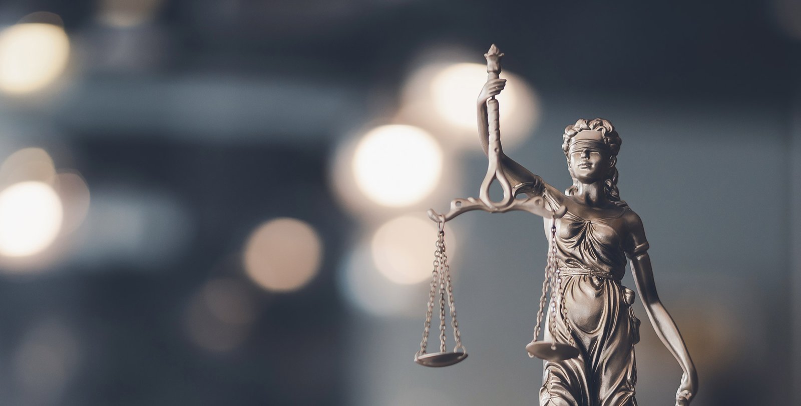 Estátua da Justiça sobre mesa de escritório de advocacia